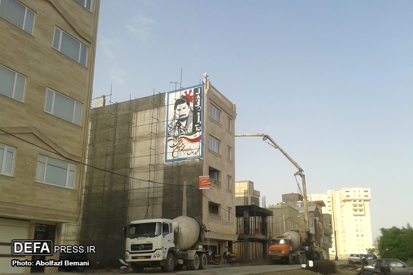 دیوارنگاری ساختمانی در قم با تصویر «شهید سراجی» از شهدای مدافع حرم/تصاویر