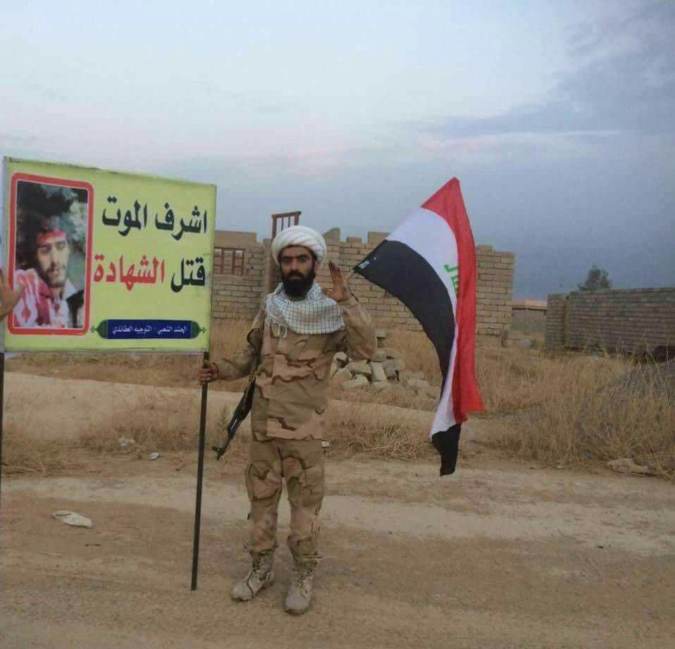 عکس یادگاری رزمنده عراقی با تصویر شهید دفاع مقدس