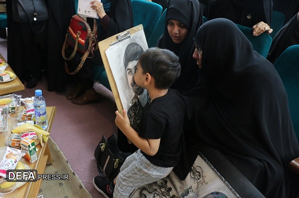 بوسه فرزند خردسال شهید مدافع حرم بر تصویر پدرش+ تصاویر