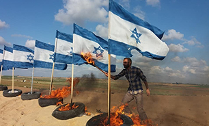 آتش کشیدن پرچم اسرائیل از سوی جوانان فلسطینی در مقابل نظامیان این رژیم