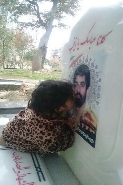 تصویر/ بوسه دختر شهید مدافع حرم بر عکس مزار پدر