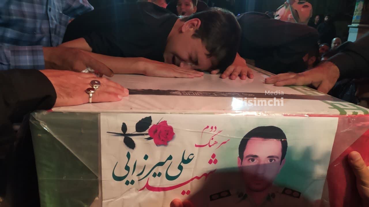 تصویر/ وداع فرزند شهید «علی میرزایی» با پیکر پدر